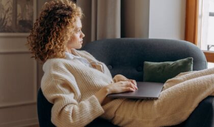 freelancer on sofa writing on a laptop