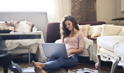 freelancer sitting on the floor writing on a laptop