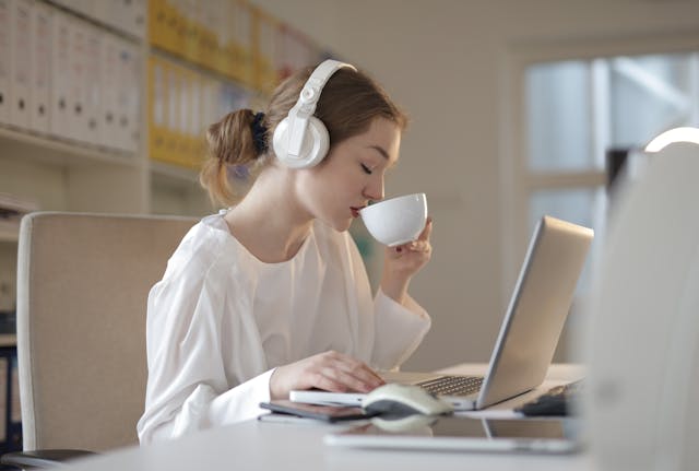 freelancer wearing headphone while sipping a coffee